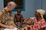 IMB Dr. Earl Hewitt examines a patient on rounds in the wards